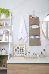 Photo of Knitted organizer hanging on wall in bathroom