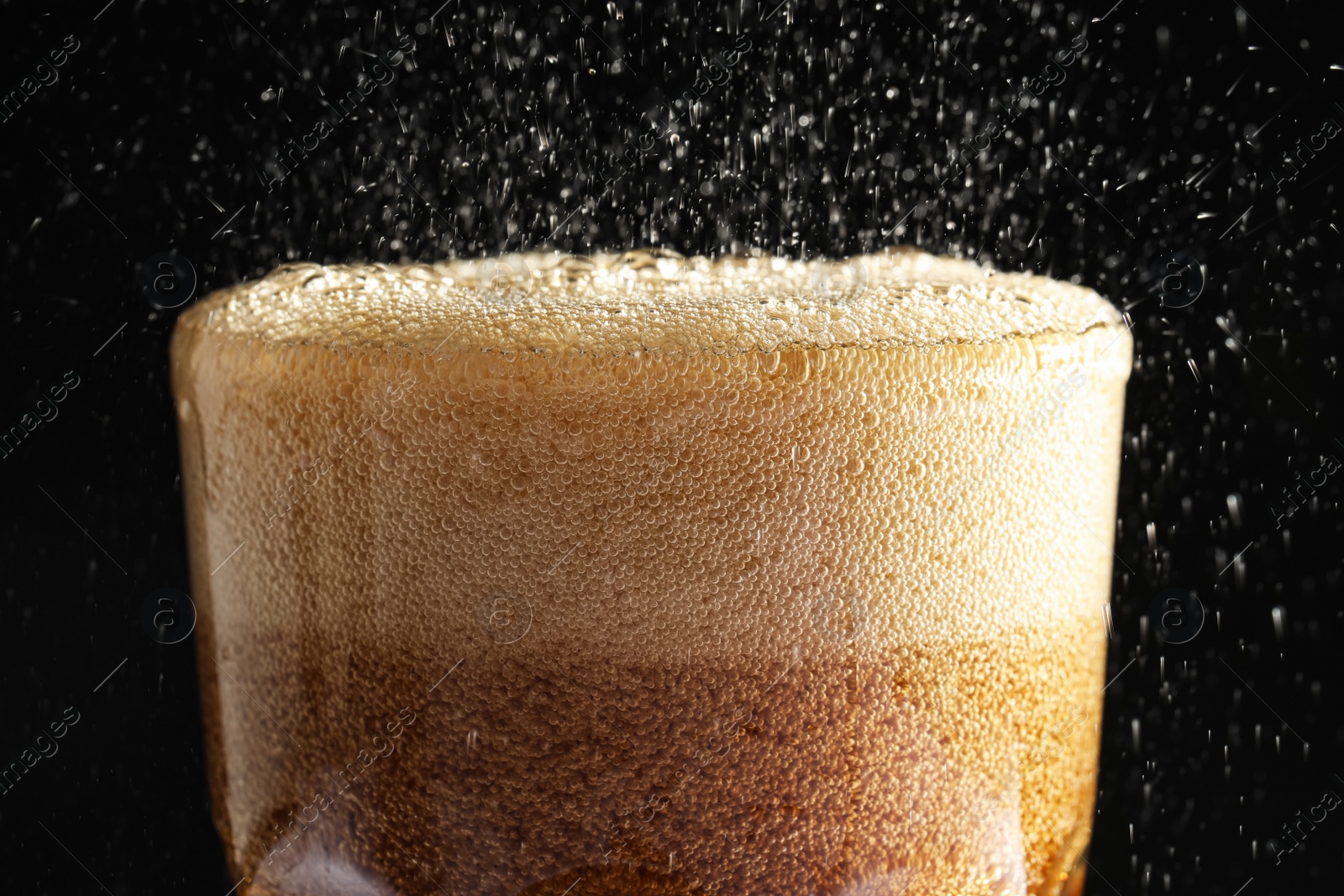 Photo of Glass of refreshing soda drink on black background, closeup