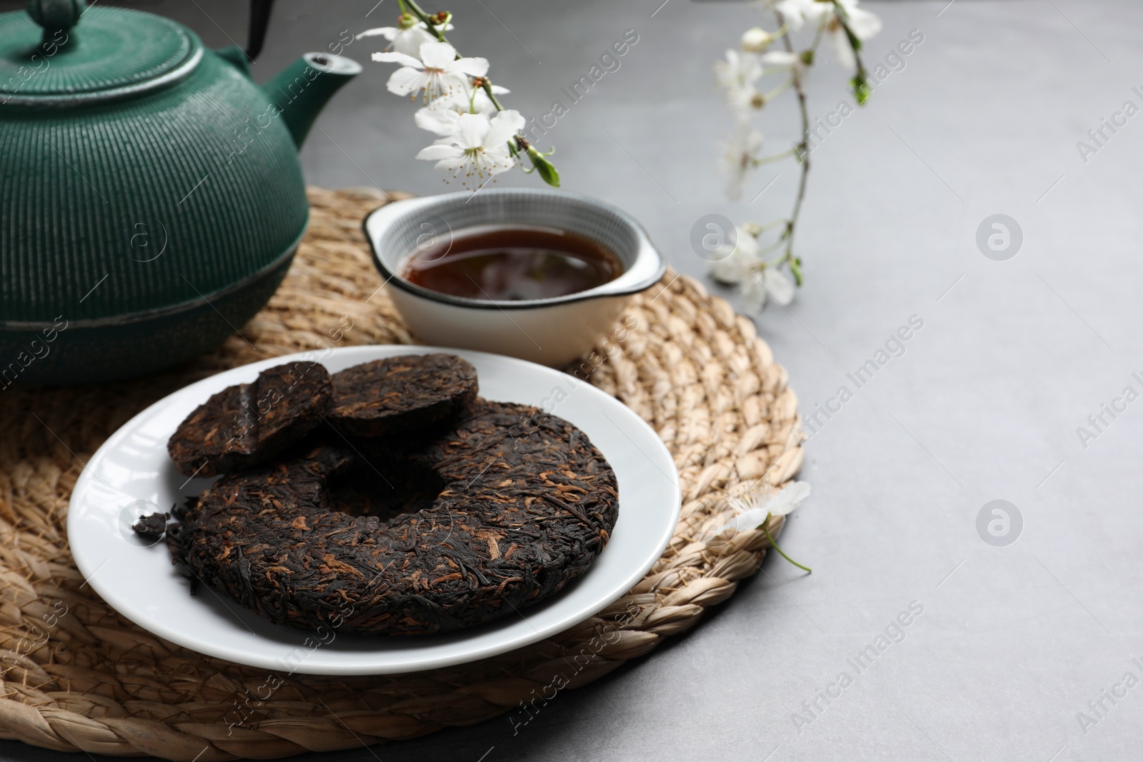 Photo of Composition with aromatic pu-erh tea on light grey table. Space for text