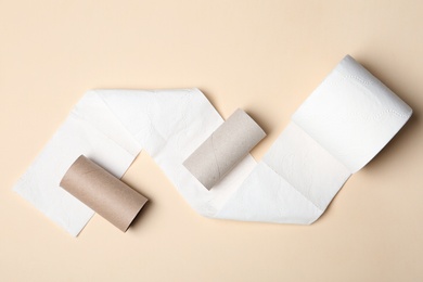 Flat lay composition with toilet paper and empty rolls on color background