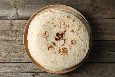 Photo of Stack of tasty homemade tortillas on wooden table, top view