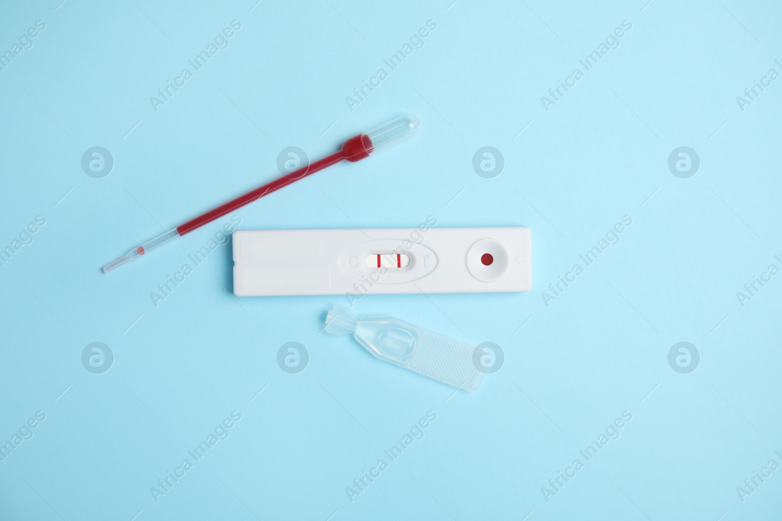 Photo of Disposable express hepatitis test kit on light blue background, flat lay