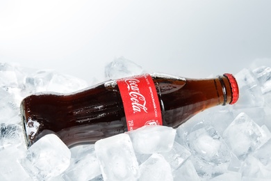 MYKOLAIV, UKRAINE - NOVEMBER 15, 2018: Bottle of Coca Cola on ice cubes against white background