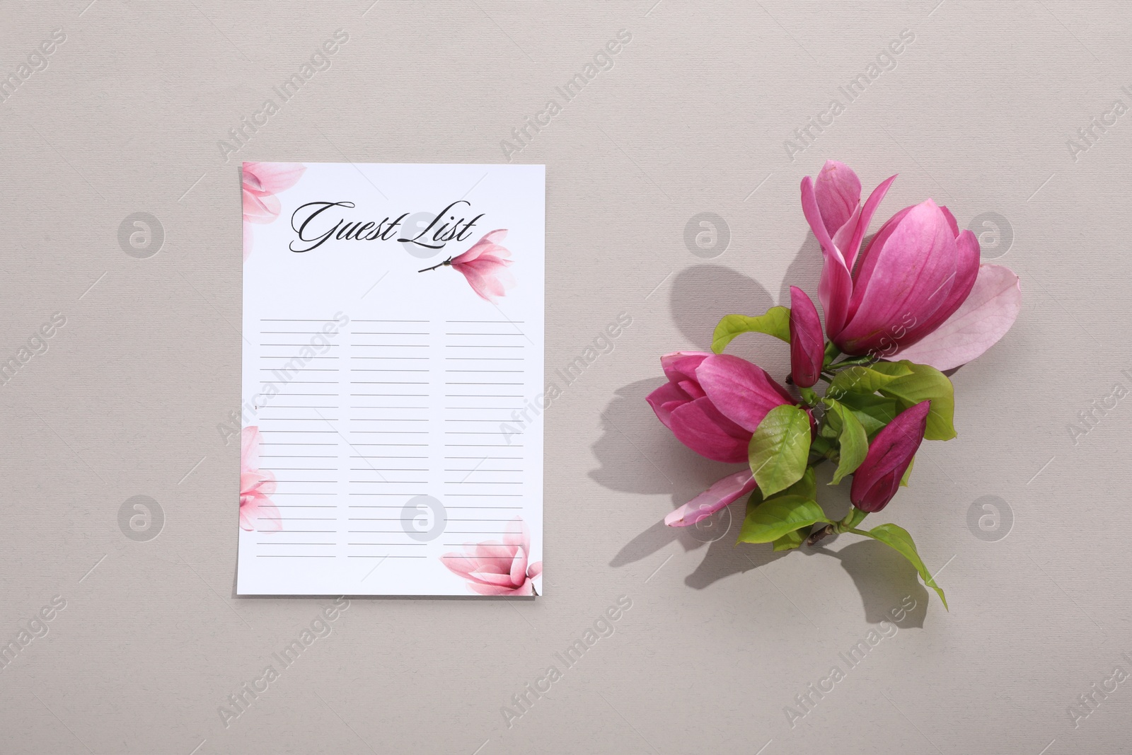 Photo of Guest list and beautiful flowers on grey background, flat lay. Space for text