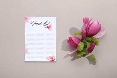 Photo of Guest list and beautiful flowers on grey background, flat lay. Space for text