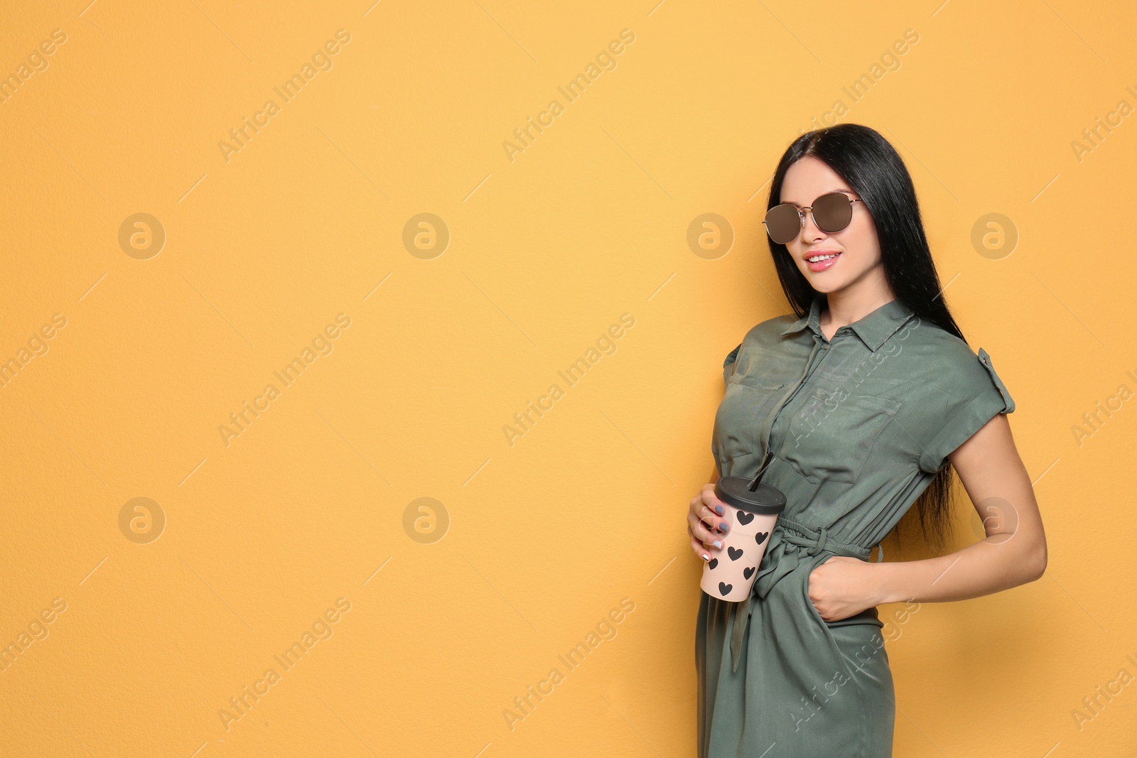 Photo of Beautiful woman in sunglasses posing on color background. Space for text