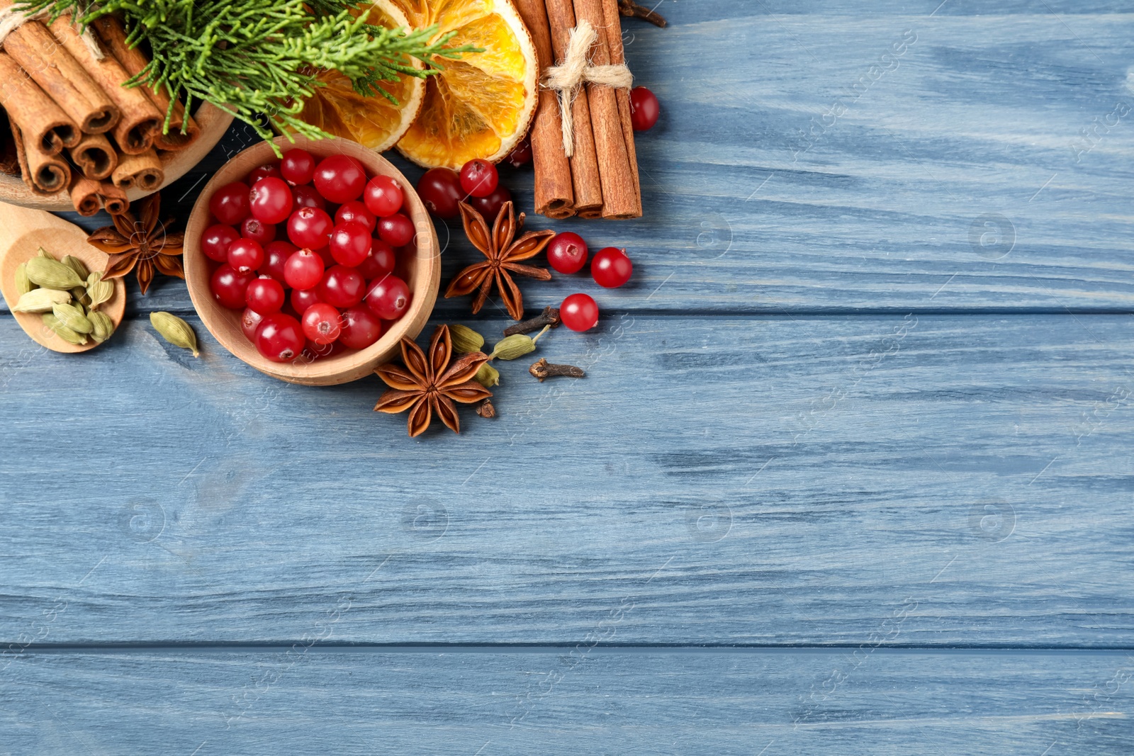 Photo of Flat lay composition with mulled wine ingredients on blue wooden table. Space for text