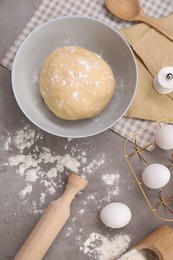Photo of Making tasty baklava. Raw dough, eggs, flour and rolling pin on grey table, flat lay