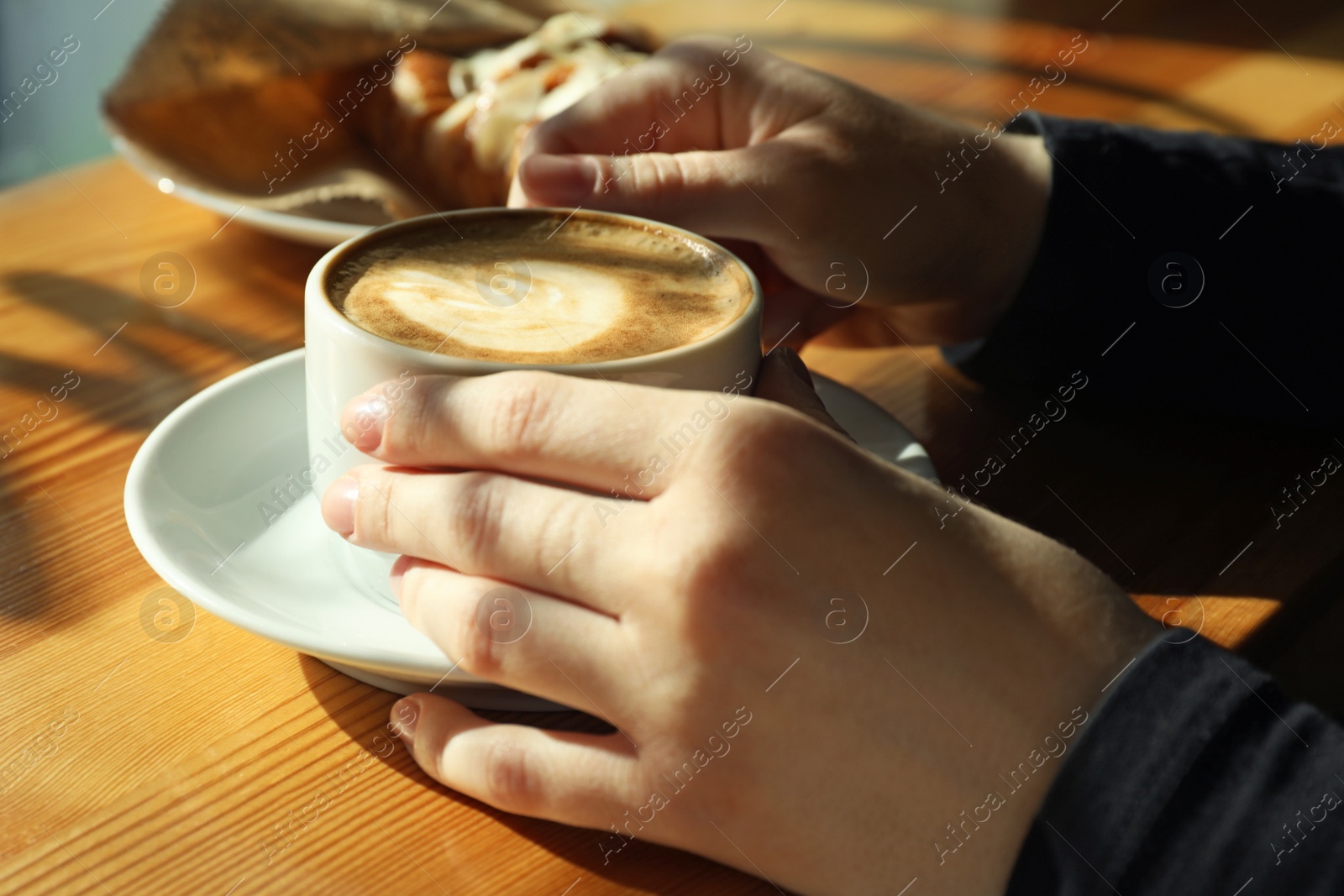 Photo of Woman with cup of fresh aromatic coffee at table in cafe