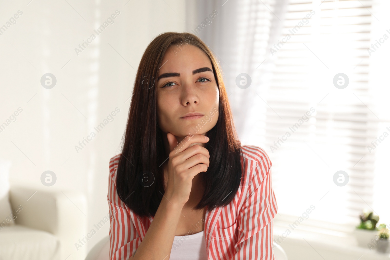 Photo of Young woman talking to her coworkers through video conference indoors, view from webcam