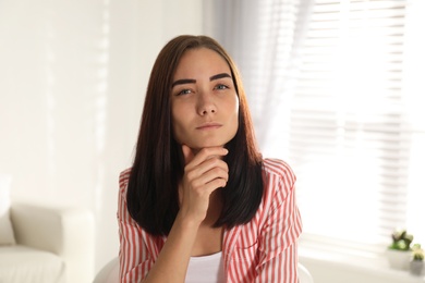 Young woman talking to her coworkers through video conference indoors, view from webcam