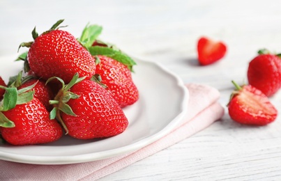 Photo of Plate with ripe red strawberries on table, closeup