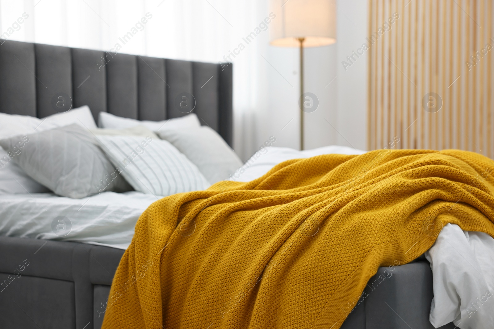 Photo of Soft plaid and pillows on bed in bedroom