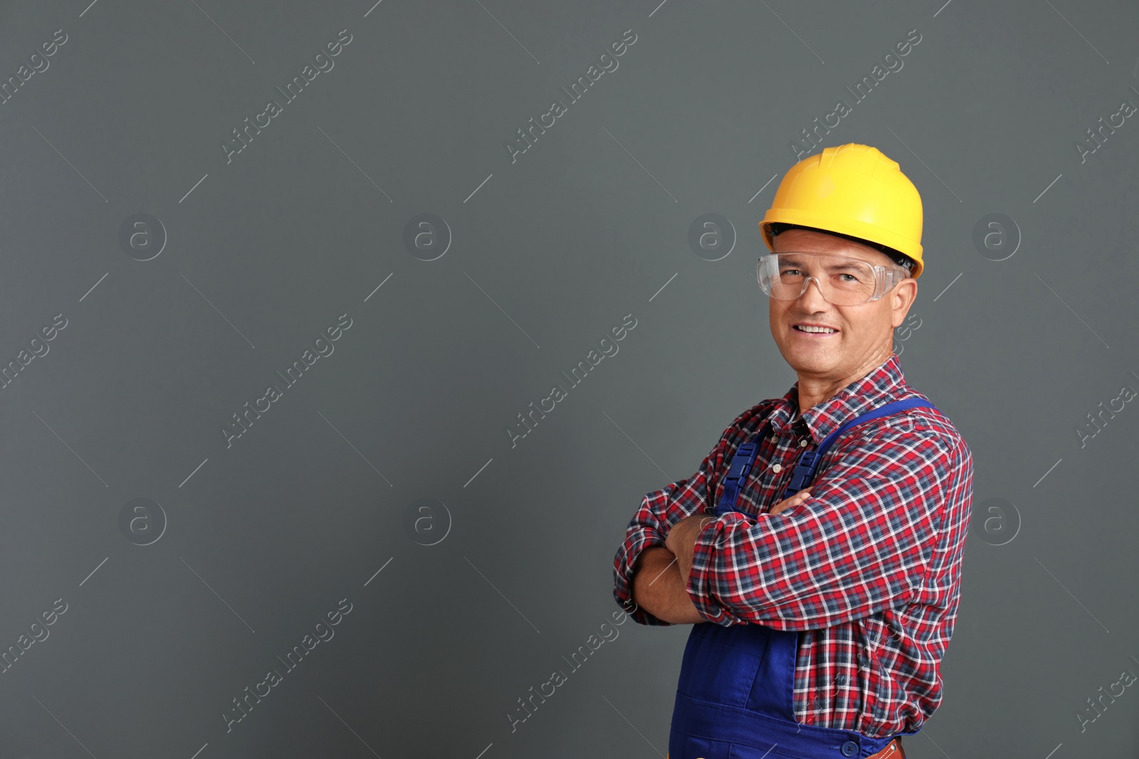 Photo of Portrait of electrician wearing uniform on gray background. Space for text