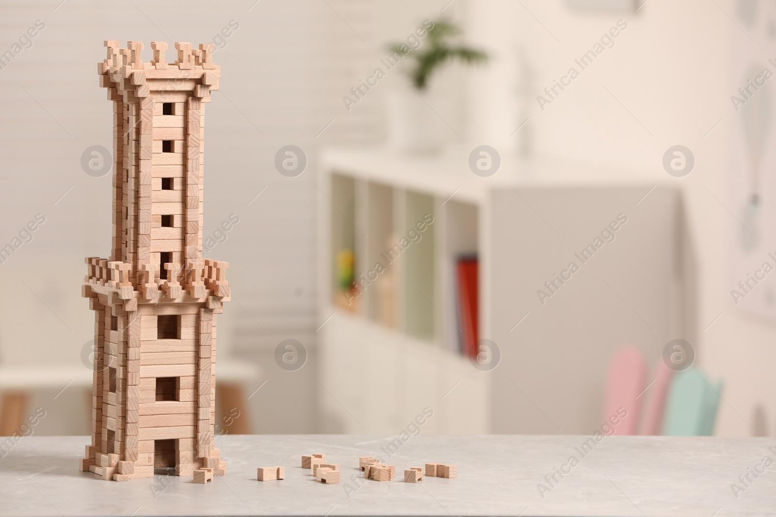 Photo of Wooden tower on table indoors, closeup. Space for text. Children's toy