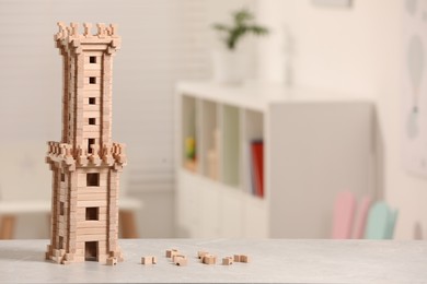 Wooden tower on table indoors, closeup. Space for text. Children's toy