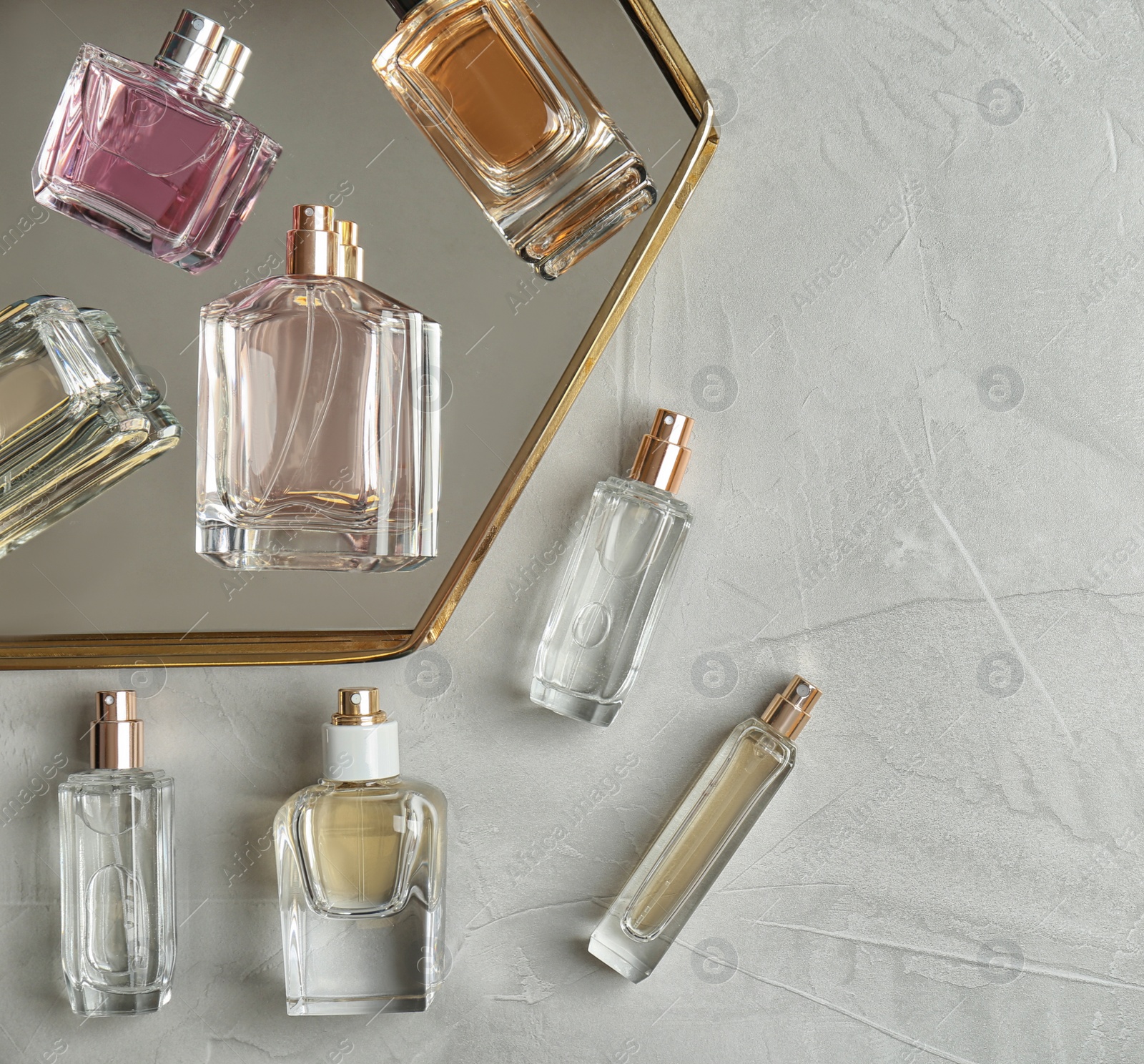 Photo of Perfume bottles on light background, flat lay