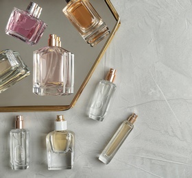 Perfume bottles on light background, flat lay