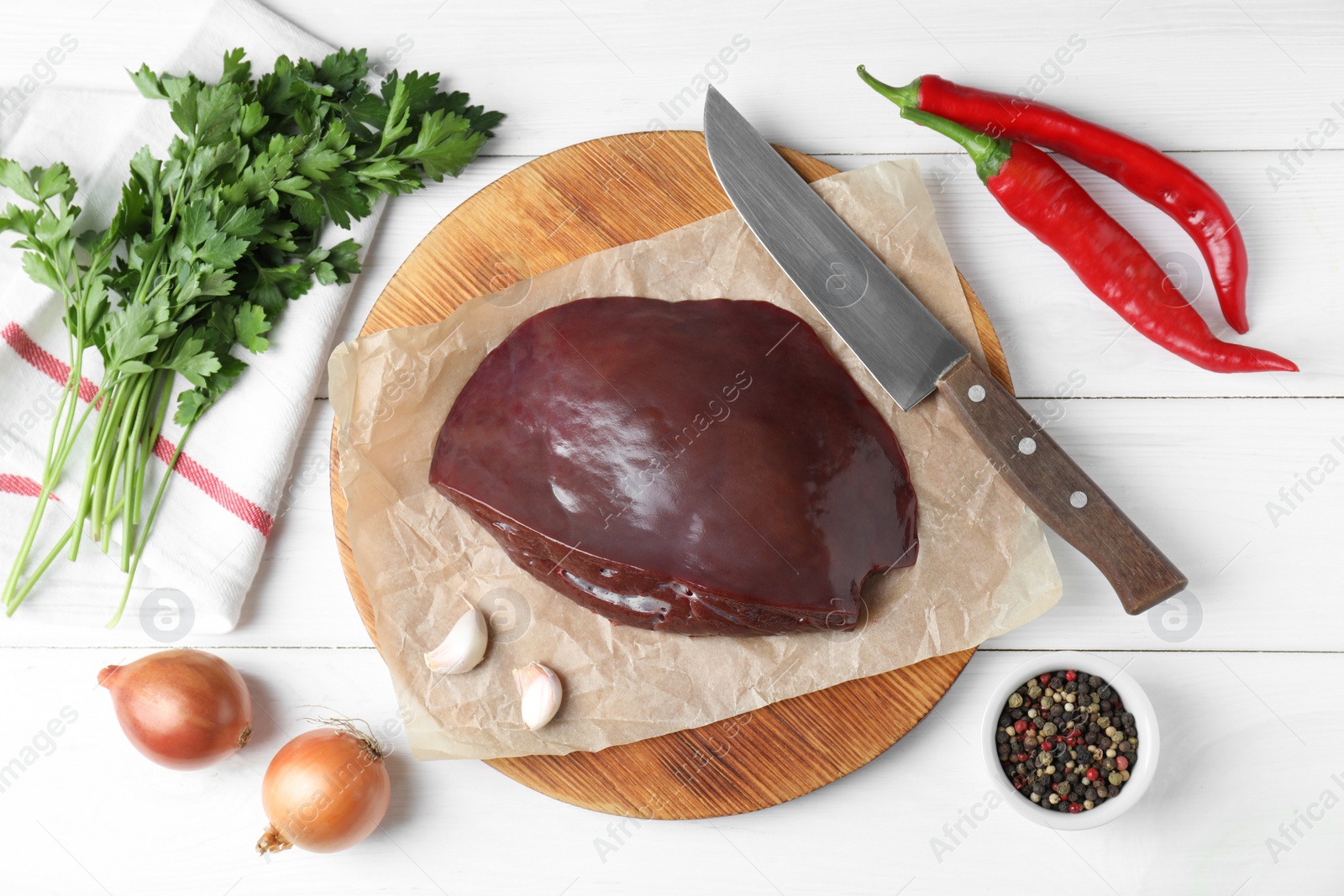 Photo of Piece of raw beef liver, knife and products on white wooden table, flat lay