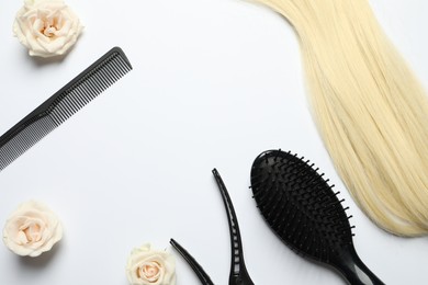 Photo of Flat lay composition with different hairdresser tools and flowers on white background, space for text