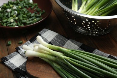 Fresh green spring onions on wooden table