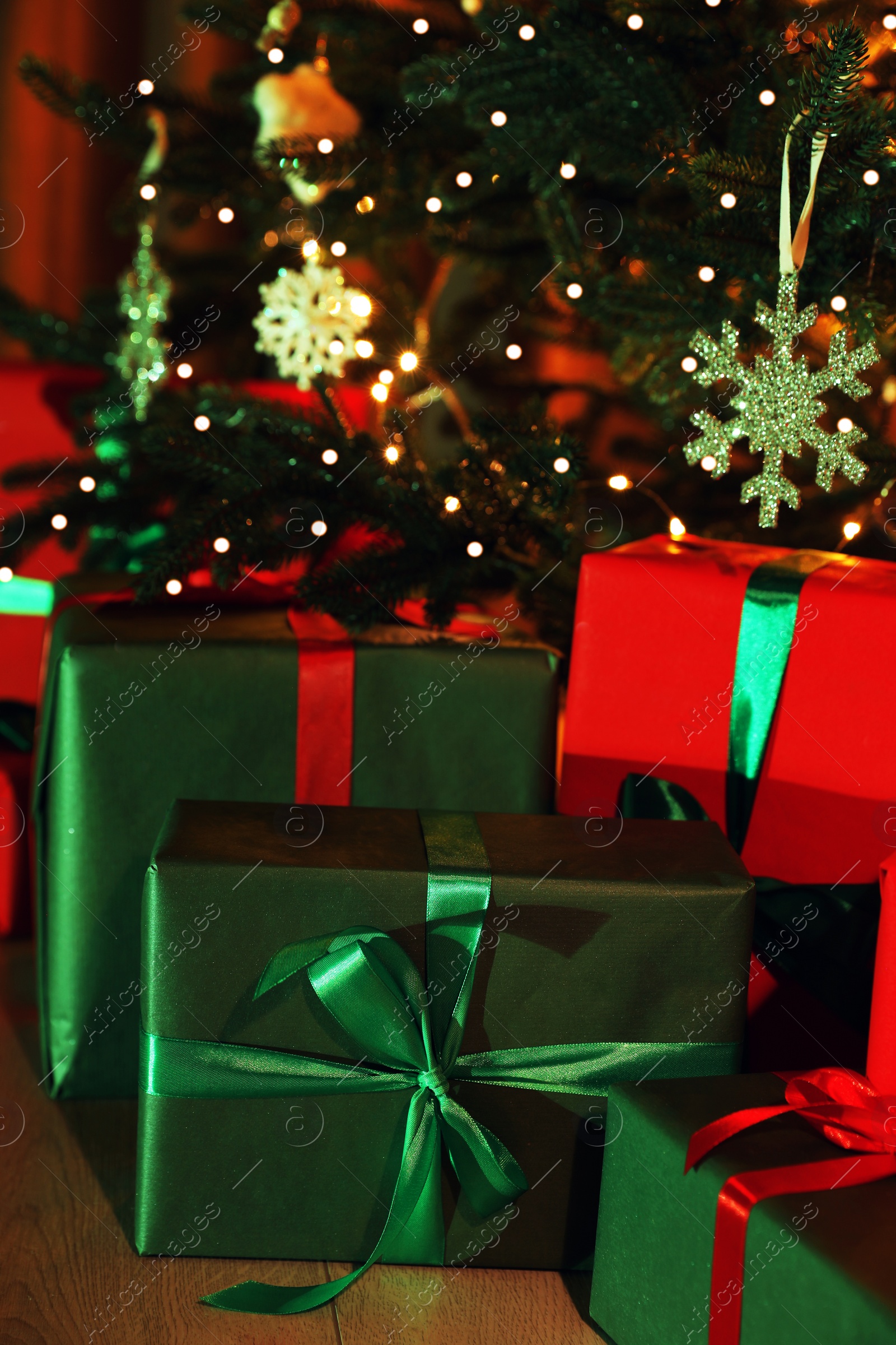 Photo of Beautifully wrapped gift boxes under Christmas tree indoors