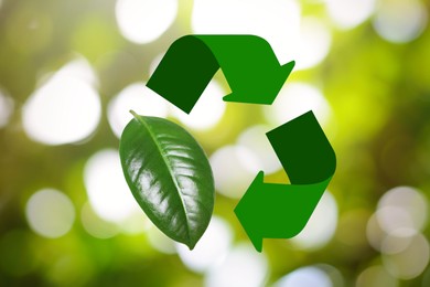 Image of Recycling symbol made of arrows and green leaf on blurred background. Bokeh effect