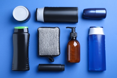 Flat lay composition with men's cosmetic products on blue background