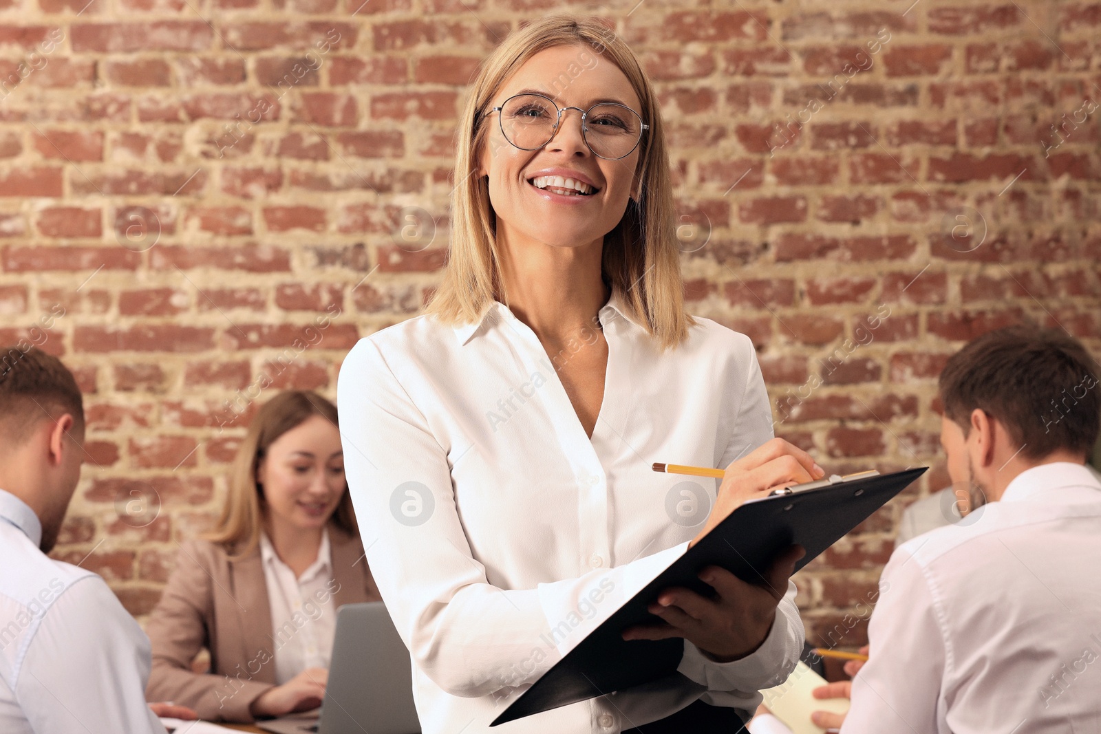 Photo of Businesswoman and her employees in office. Lady boss