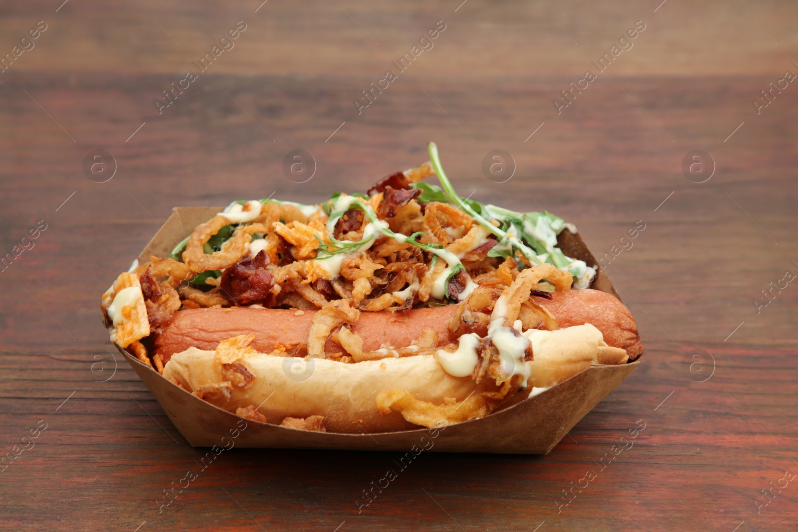 Photo of Fresh delicious hot dog on wooden table