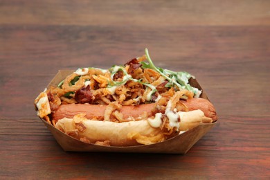 Photo of Fresh delicious hot dog on wooden table