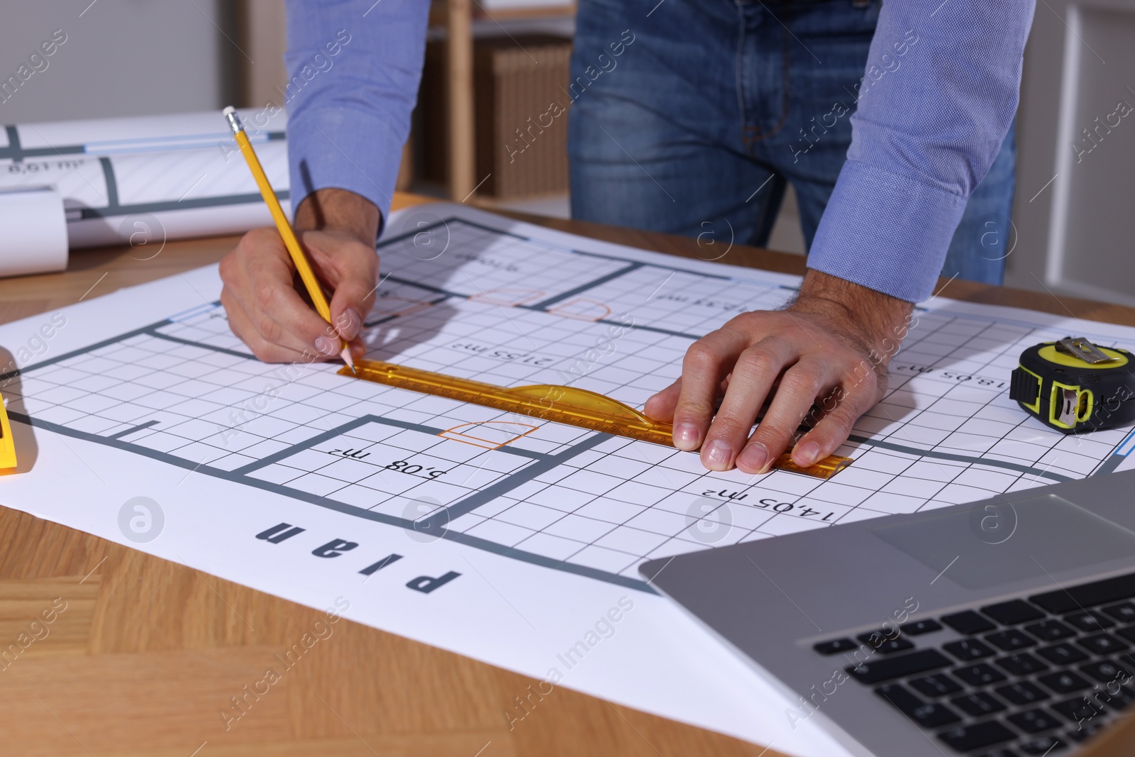 Photo of Architect working with construction drawings in office, closeup