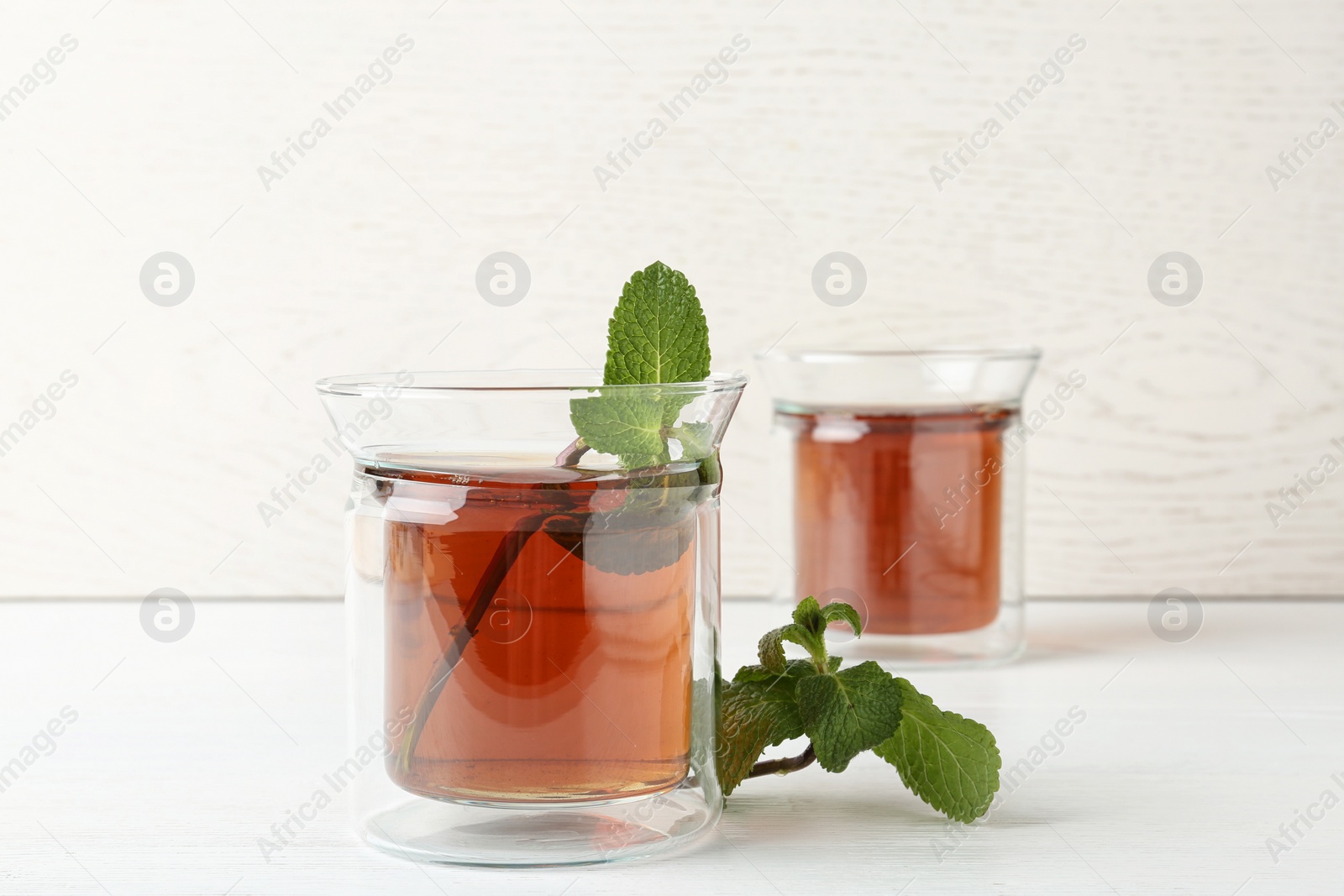 Photo of Glass cups with tasty tea on white table