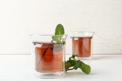 Photo of Glass cups with tasty tea on white table