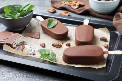 Photo of Glazed ice cream bars, fresh mint and chocolate on baking tray