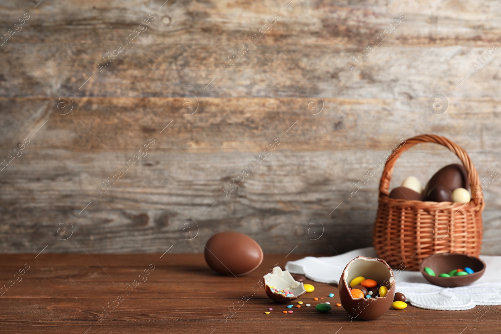 Photo of Beautiful composition with chocolate Easter eggs on wooden table. Space for text