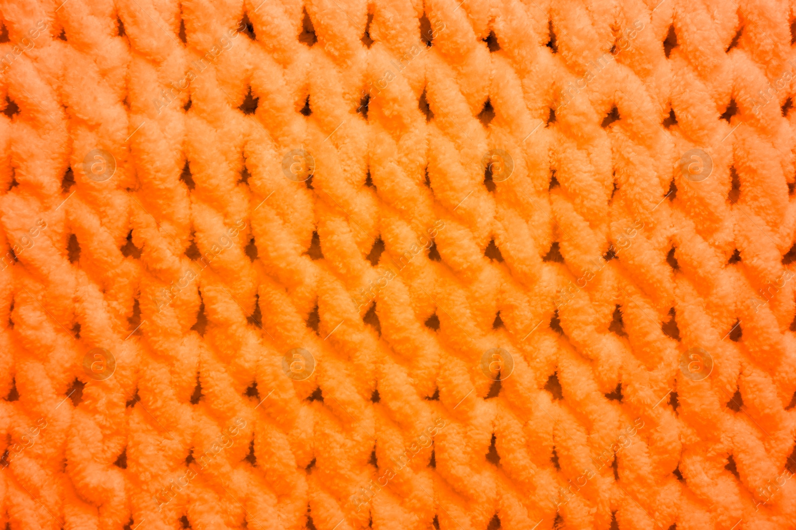 Image of Soft orange knitted fabric as background, top view