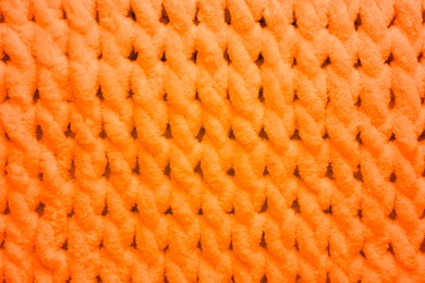 Soft orange knitted fabric as background, top view