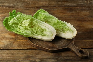Photo of Cut fresh ripe Chinese cabbage on wooden table