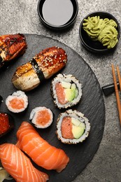 Photo of Set of delicious sushi rolls on dark grey table, flat lay