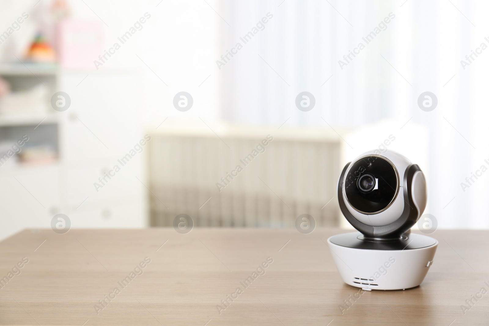 Photo of Baby camera on table in room, space for text. Video nanny