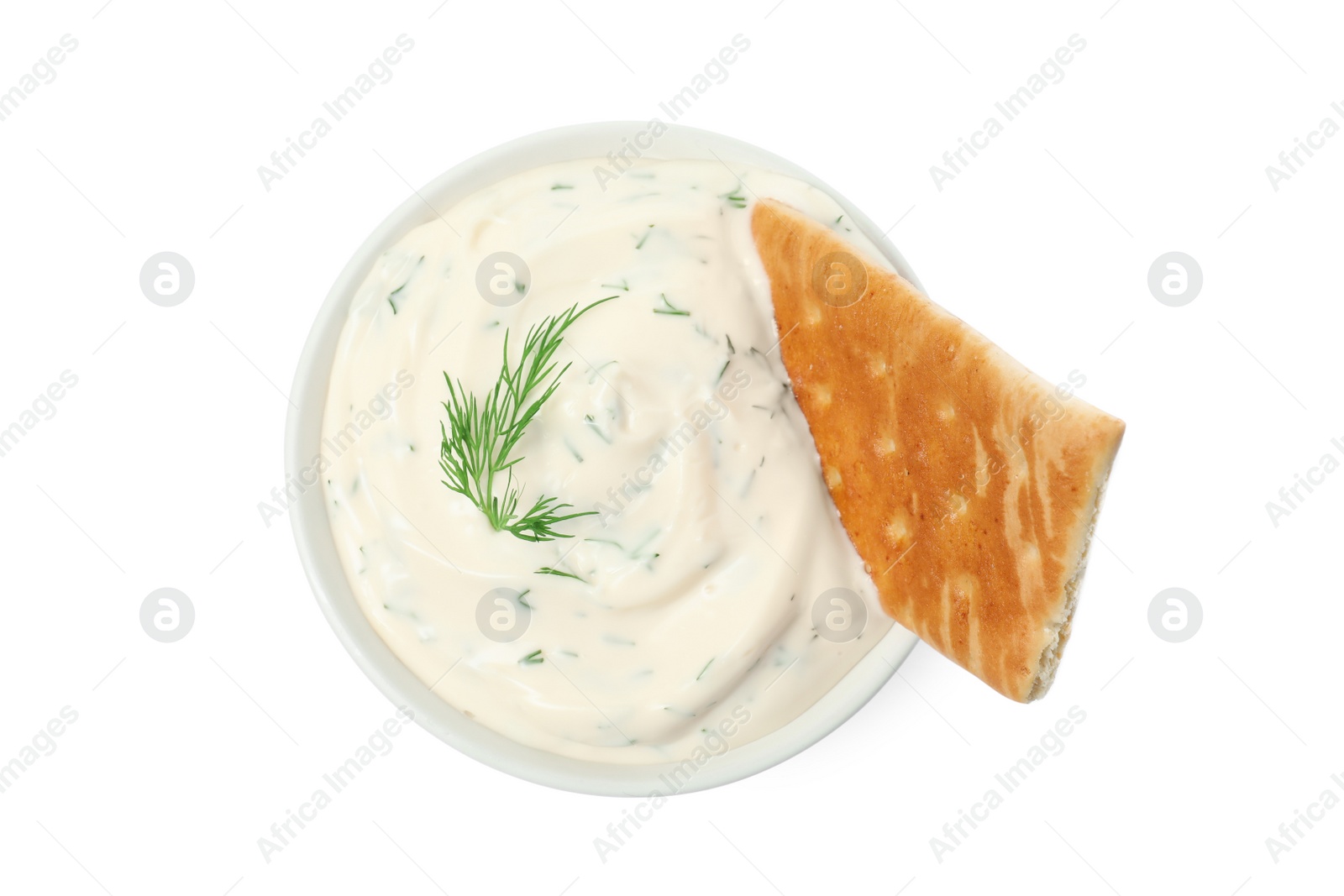 Photo of Tasty creamy dill sauce with cracker in bowl isolated on white, top view