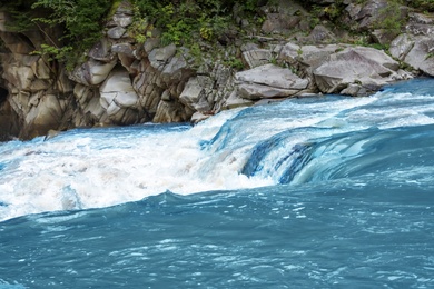 Photo of Mountain river flowing along rocky banks in wilderness