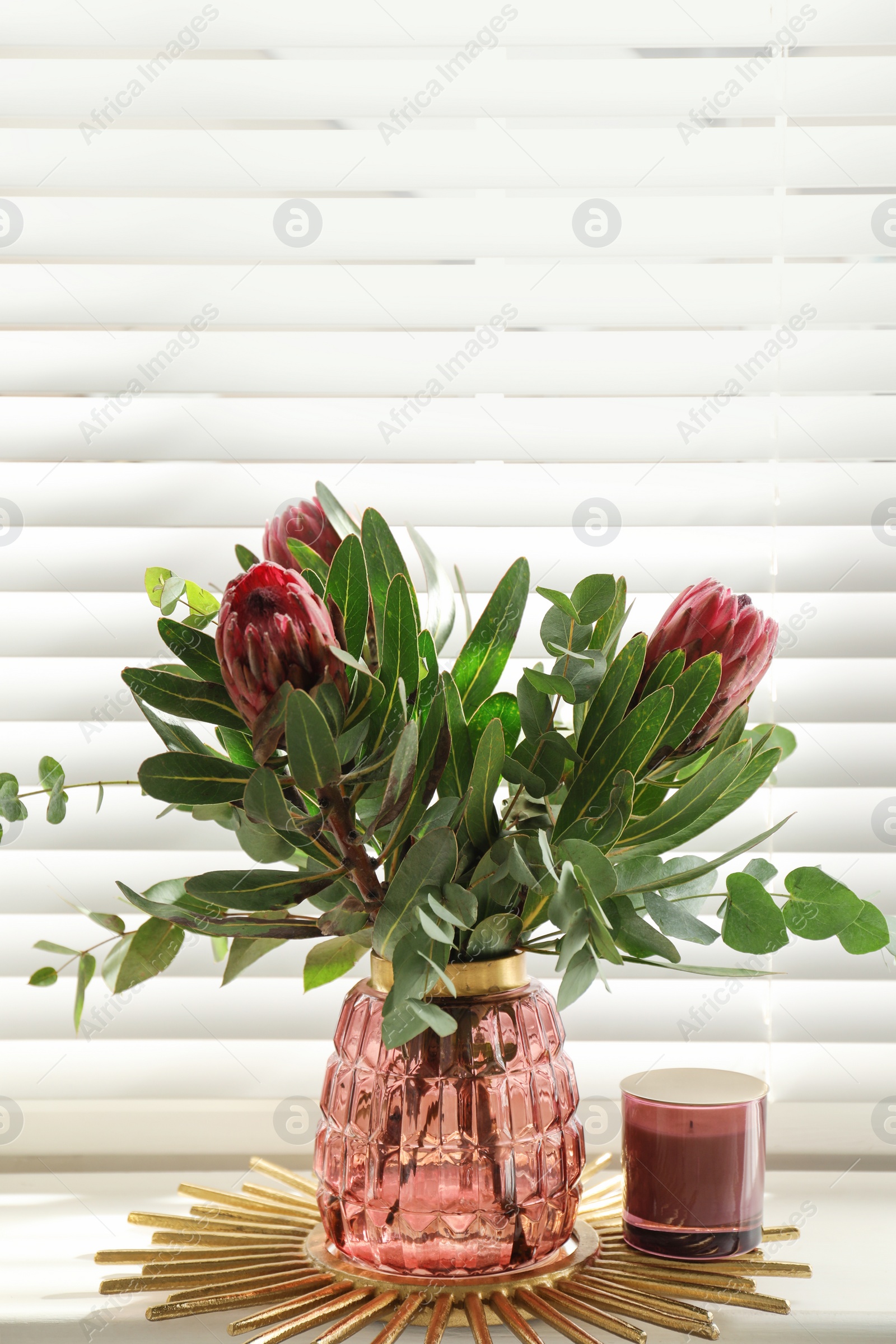 Photo of Vase with bouquet of beautiful Protea flowers on window sill indoors