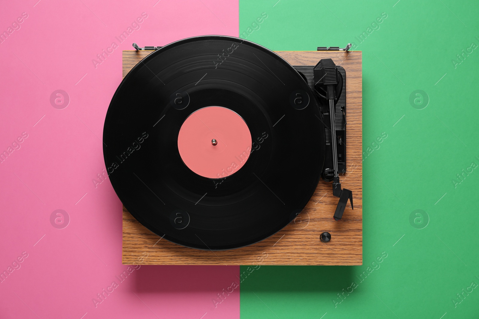 Photo of Modern turntable with vinyl record on color background, top view