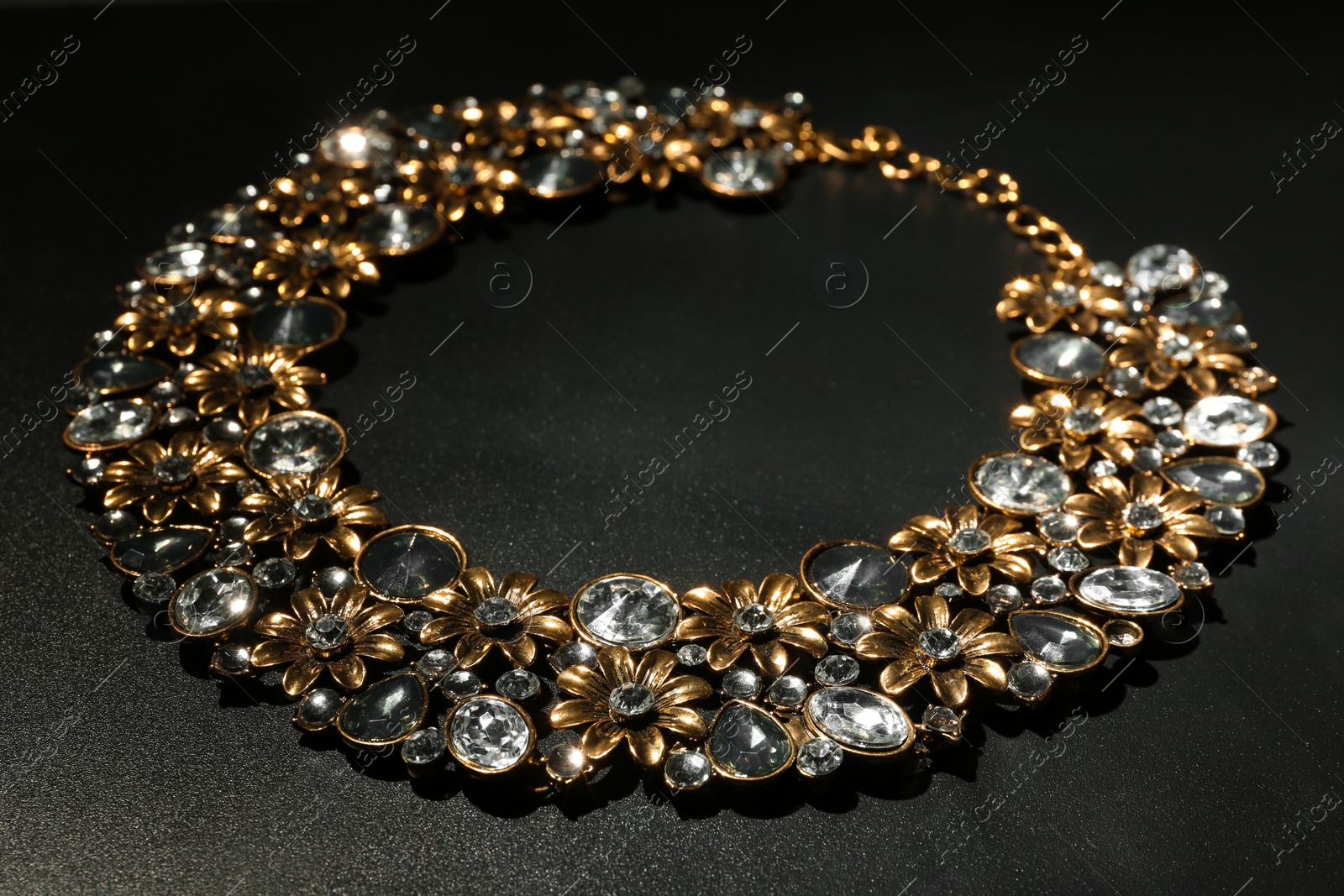 Photo of Stylish necklace with gemstones on black background, space for text. Luxury jewelry