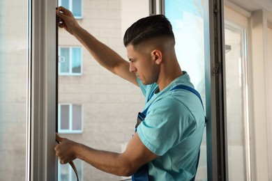 Photo of Worker putting rubber draught strip onto window