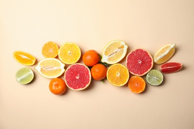 Different citrus fruits on color background, top view