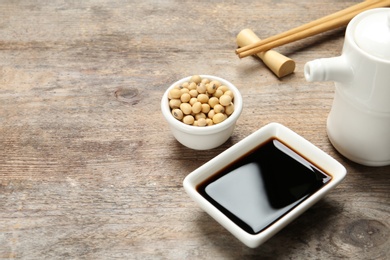 Dish of soy sauce served on wooden table. Space for text