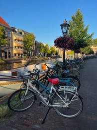 Leiden, Netherlands - August 1, 2022: Picturesque view of city street with parked bicycles and beautiful buildings along canal